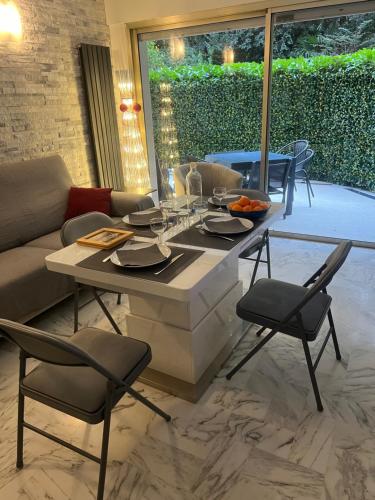 une table à manger et des chaises dans un salon dans l'établissement Chic 47m2, 2 rooms, ground floor, nice patio, 280m beach Croisette, à Cannes