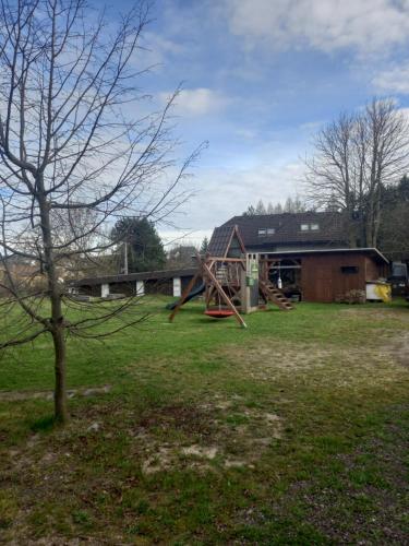a playground in a field next to a building at Chalupa U Kravína in Rtyně v Podkrkonoší