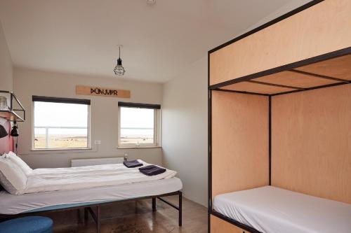 a room with two bunk beds and a window at Midgard Base Camp in Hvolsvöllur