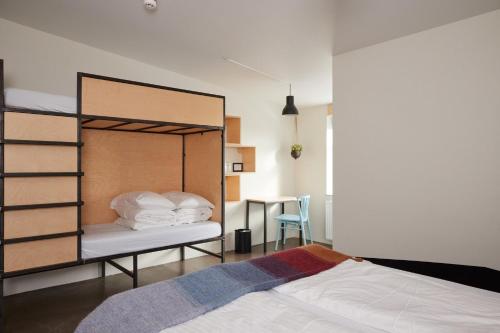 a bedroom with a bunk bed and a desk at Midgard Base Camp in Hvolsvöllur