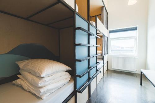 a bedroom with a bunk bed with pillows on it at Midgard Base Camp in Hvolsvöllur