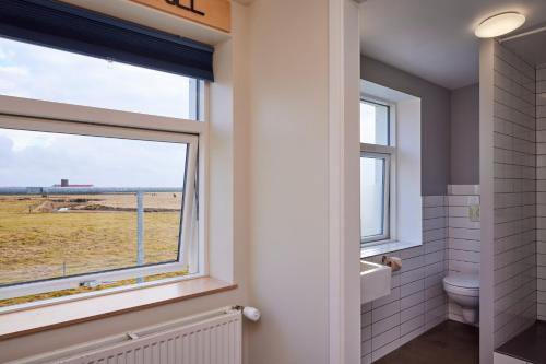 a bathroom with a window with a view of a field at Midgard Base Camp in Hvolsvöllur