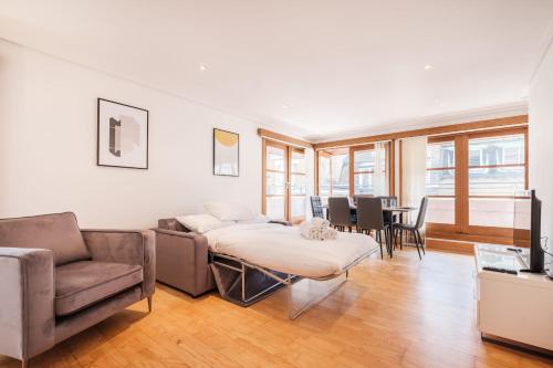 un soggiorno con divano e tavolo di 2BR Penthouse with Terrace - Heart of Holborn - CityApartmentStay a Londra