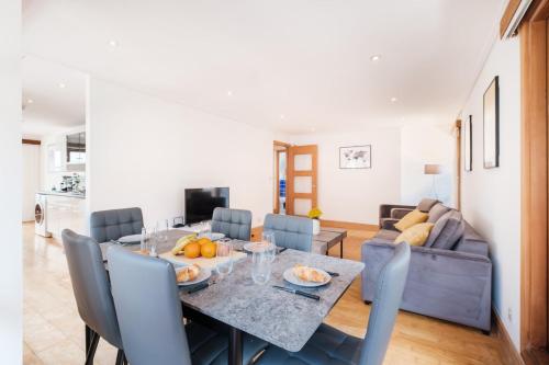 una sala da pranzo con tavolo e divano di 2BR Penthouse with Terrace - Heart of Holborn - CityApartmentStay a Londra