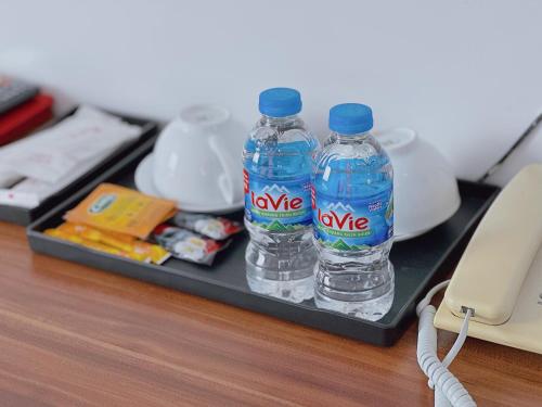 2 Flaschen Wasser auf einem Tablett auf einem Schreibtisch in der Unterkunft Apple Hotel in Cần Thơ