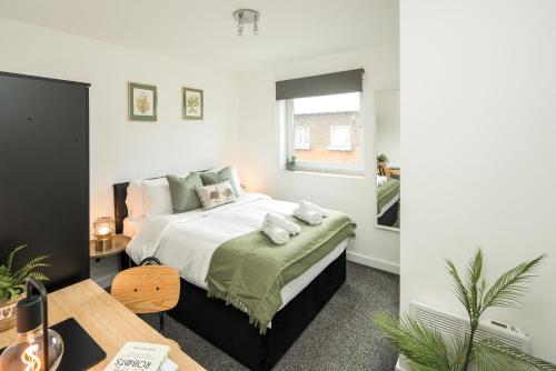 a bedroom with a bed and a desk and a window at CanaryWharf Apartments by Sleepy in London