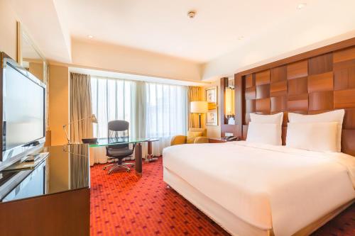 a hotel room with a large bed and a desk at Beijing Pudi Hotel in Beijing