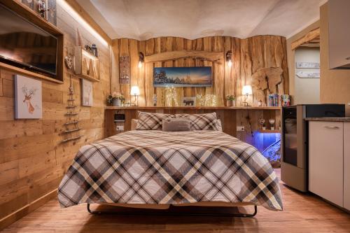 a bedroom with a bed and wooden walls at LA ROCCIA - CASA VACANZA in Borgo San Dalmazzo