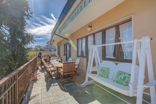 un balcone con sedie e un tavolo su un balcone di Blooming Villa Cos Lake View - Happy Rentals a Belgirate