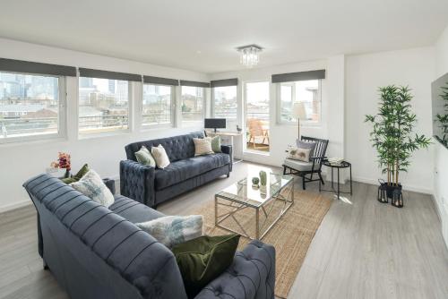 a living room with two couches and a table at CanaryWharf Apartments by Sleepy in London