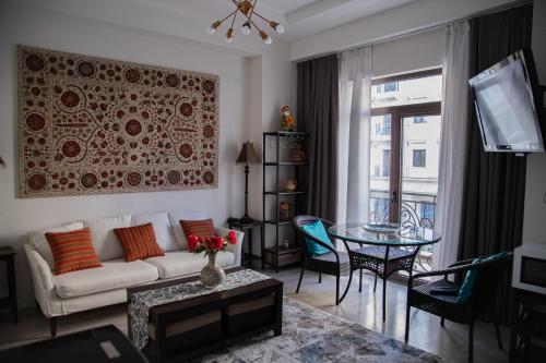 una sala de estar con un sofá y una mesa en 2BR Tashkent City Fountain view, en Tashkent
