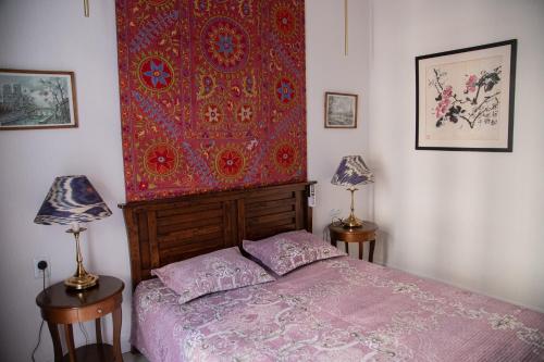 塔什坎的住宿－2BR Tashkent City，卧室配有一张床,墙上挂着多彩的挂毯