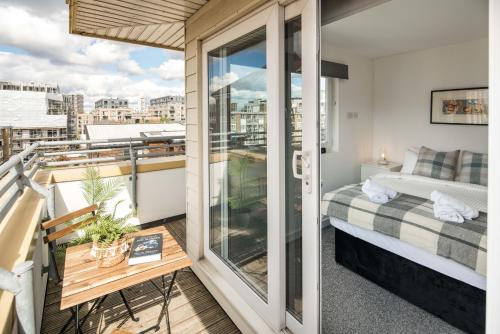 a balcony with a bed and a view of a city at CanaryWharf Apartments by Sleepy in London