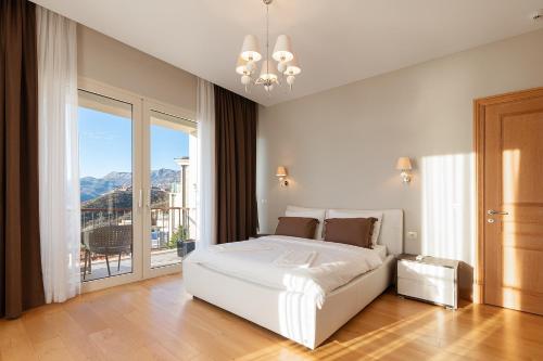 a bedroom with a white bed and a large window at Villa Hedonism in Sveti Stefan