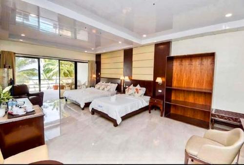 a bedroom with two beds and a living room at Lukay Las Brisas in Boracay
