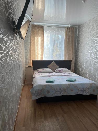 a bedroom with a bed and a window at Конгресс in Petropavlovsk
