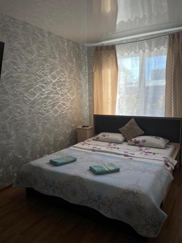a bedroom with a bed with two towels on it at Конгресс in Petropavlovsk