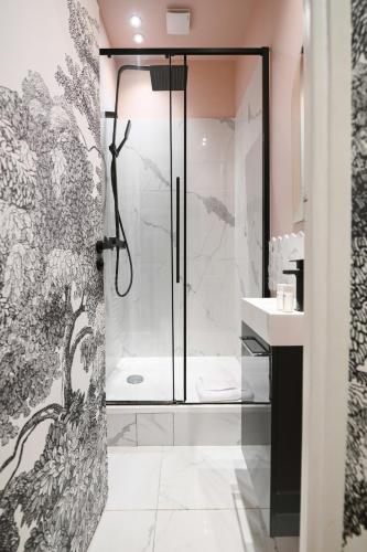 une douche avec une porte vitrée dans une salle de bain dans l'établissement Le Marais Pl de la Bastille 3BD 3BTH for 10 guests, à Paris