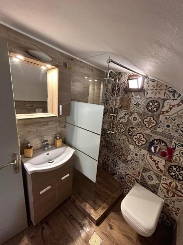 a bathroom with a sink and a toilet at Villa Markos in Perissa