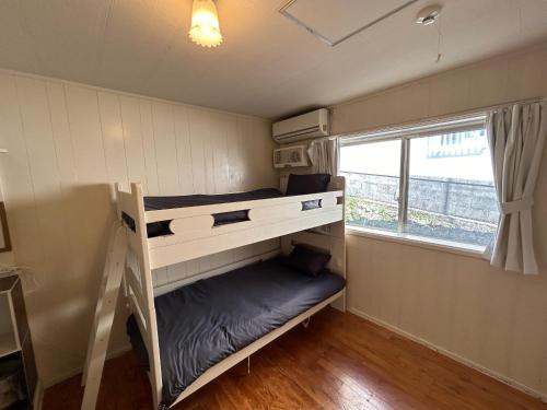ein Schlafzimmer mit Etagenbetten in einem winzigen Haus in der Unterkunft ホロホロバイライフタイム in Furugen