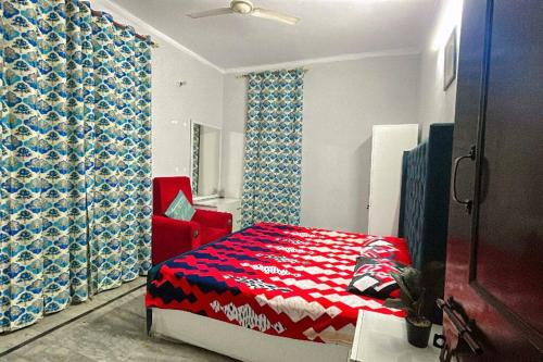 a bedroom with a red bed and a red chair at work stay enjoy outdoor party in Faridabad