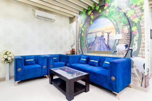 a blue couch in a living room with a table at Treebo Royal Imperial, Bikaner Railway Station in Bikaner