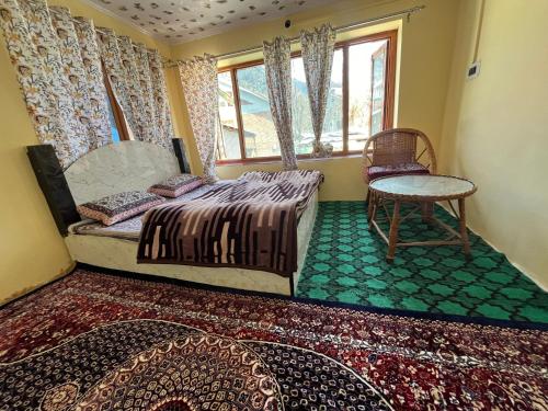 a bedroom with a bed and a table and a window at Pine Brooke in Anantnāg
