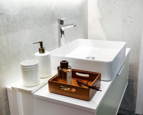 a bathroom with a white sink and a wooden tray at Kula Kerameikos in Athens