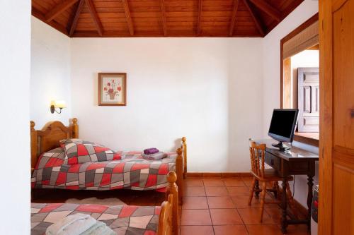 1 dormitorio con 1 cama y escritorio con ordenador en Casa La Podona- A, en Jedey