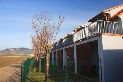 un edificio con una valla junto a un árbol en Duplex apartmán Pálava en Dolní Dunajovice