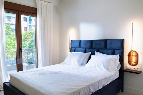 a large bed with a blue headboard in a bedroom at Kula Kerameikos in Athens