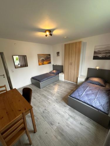 a room with two beds and a table in it at Schöne Apartments in Königsdorf BM01 bis BM04 in Frechen