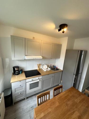 cocina con armarios blancos y mesa de madera en BM01 bis BM04 Schöne Apartments in Frechen, en Frechen