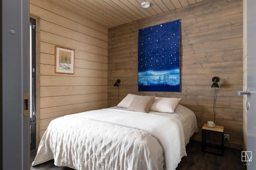 ein Schlafzimmer mit einem Bett und einem Wandgemälde in der Unterkunft Ellivuori Chalet Moisio in Sastamala