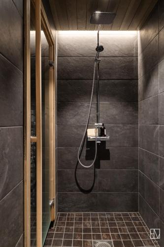 a bathroom with a shower with a shower head at Ellivuori Chalet Moisio in Sastamala