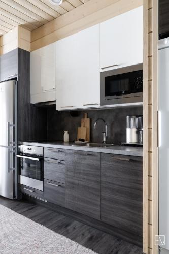 a kitchen with white cabinets and stainless steel appliances at Ellivuori Chalet Moisio in Sastamala