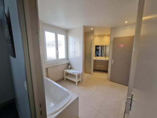un baño con bañera y lavabo en Logis Hôtel Restaurant Clair Cottage, Chisseaux - Chenonceaux, en Chisseaux