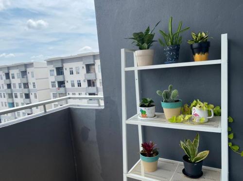 a white shelf with potted plants on a balcony at Al-Amin Homestay, Jasin, Melaka in Jasin