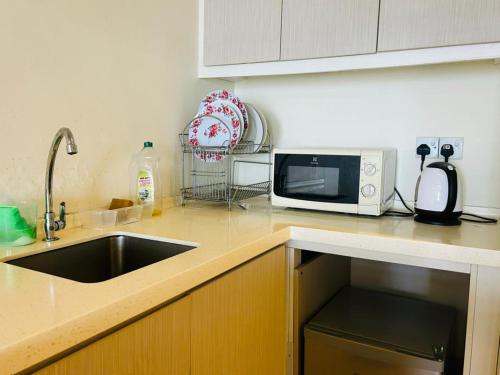 a kitchen counter with a sink and a microwave at SAMI APARTMENT - Times Square KL in Kuala Lumpur
