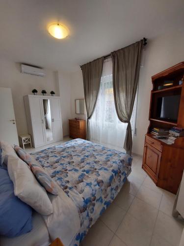 ein Schlafzimmer mit einem großen Bett und einem TV in der Unterkunft Casa Armilla in La Spezia