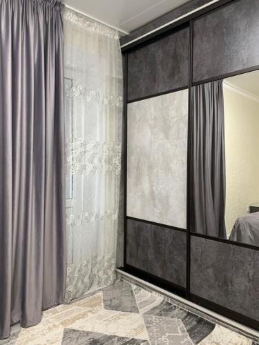 a bedroom with a large mirror and gray curtains at ИП.МЕДИНА in Taraz