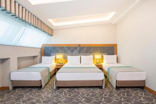 a hotel room with two beds and two lamps at Vicenza Hotel Istanbul Old City in Istanbul