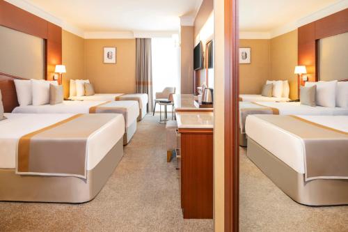 a hotel room with three beds and a desk at Vicenza Hotel Istanbul Old City in Istanbul