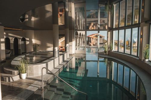 una piscina cubierta en un edificio con ventanas de cristal en Solea Boutique & Spa Hotel, en Fai della Paganella