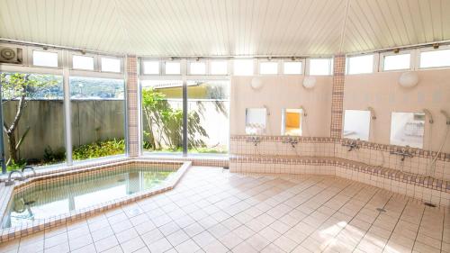 a large bathroom with a swimming pool and windows at エトワール生石 in Yura