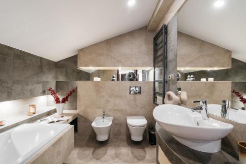 Un baño con lavabo, bañera e inodoro. en Boho Lofts - LoftAffair, en Cracovia