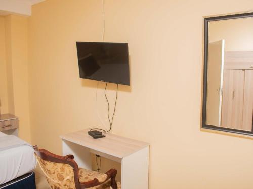 a room with a desk with a television on the wall at River-Ridge Guest House in Gaborone