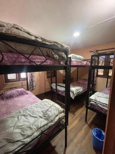 a room with three bunk beds in it at Nirvaan Guest House (Hotel Bibidh) in Kathmandu
