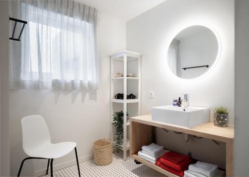 a bathroom with a white sink and a mirror at Zeegalm Bungalows in Middelkerke