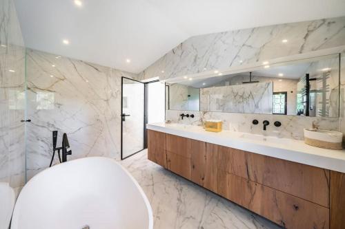 une salle de bain avec deux lavabos et un grand miroir dans l'établissement Mougins magnifique villa renové, à Mougins